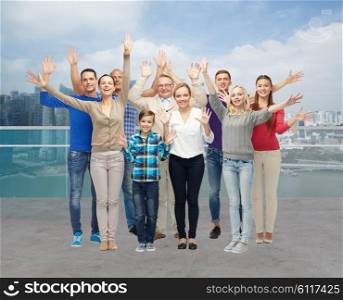 tourism, travel, generation and people concept - group of smiling men, women and boy waving hands over singapore city waterside background