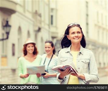 tourism, travel, leisure and holidays and friendship concept - smiling teenage girls with city guide, map and camera outdoors