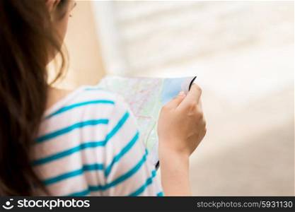tourism, travel, leisure and holidays concept - close up of woman reading map