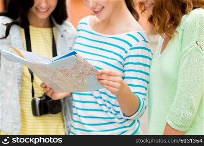 tourism, travel, leisure, holidays and friendship concept - close up of smiling teenage girls with map and camera outdoors