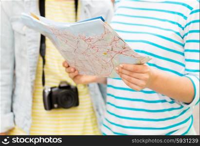 tourism, travel, leisure, holidays and friendship concept - close up of women with map and camera outdoors