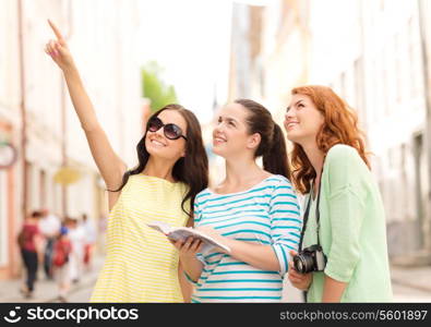 tourism, travel, leisure, holidays and friendship concept - smiling teenage girls with city guide and camera outdoors