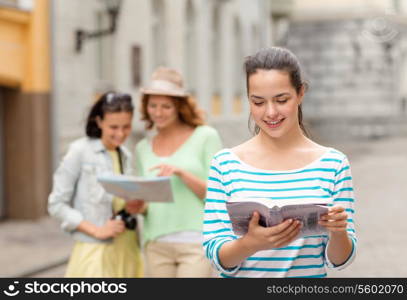 tourism, travel, leisure, holidays and friendship concept - smiling teenage girls with city guide, map and camera outdoors