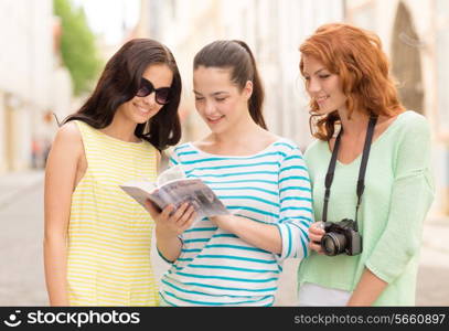 tourism, travel, leisure, holidays and friendship concept - smiling teenage girls with city guide and camera outdoors