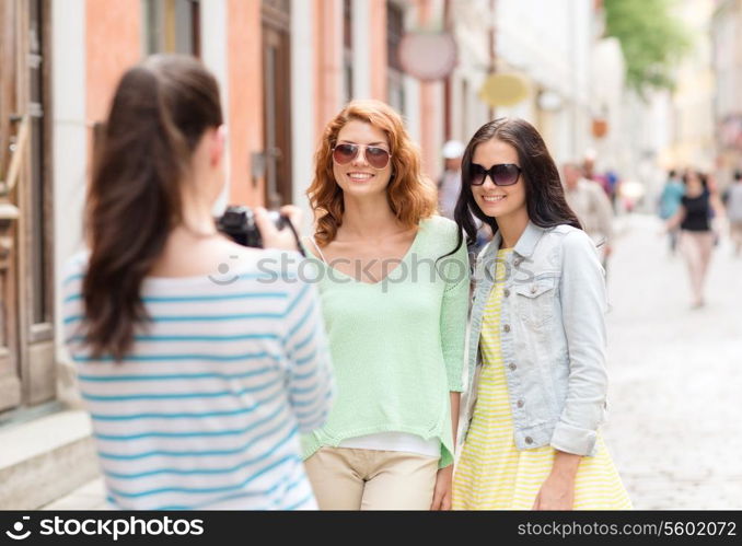 tourism, travel, leisure, holidays and friendship concept - smiling teenage girls with camera outdoors