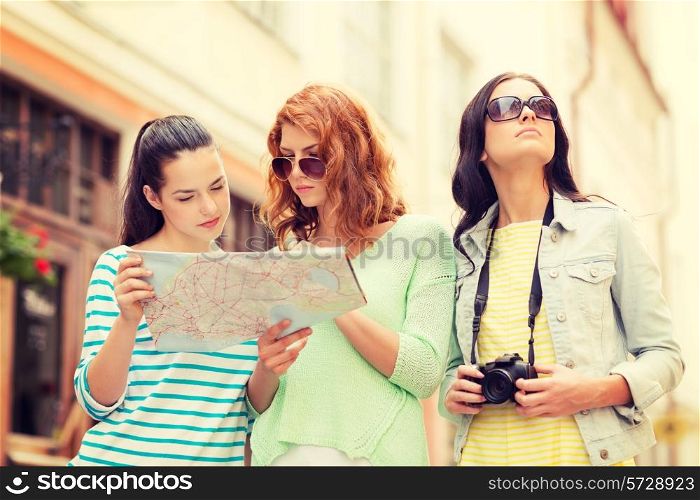 tourism, travel, leisure, holidays and friendship concept - teenage girls with map and camera outdoors