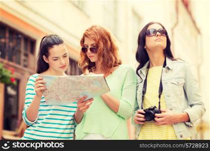 tourism, travel, leisure, holidays and friendship concept - teenage girls with map and camera outdoors