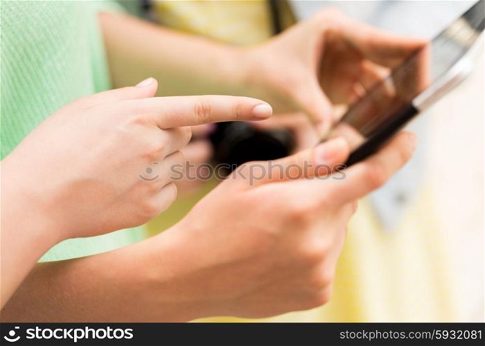 tourism, travel, leisure, holidays and technology concept - close up of women hands with tablet pc computer and camera outdoors
