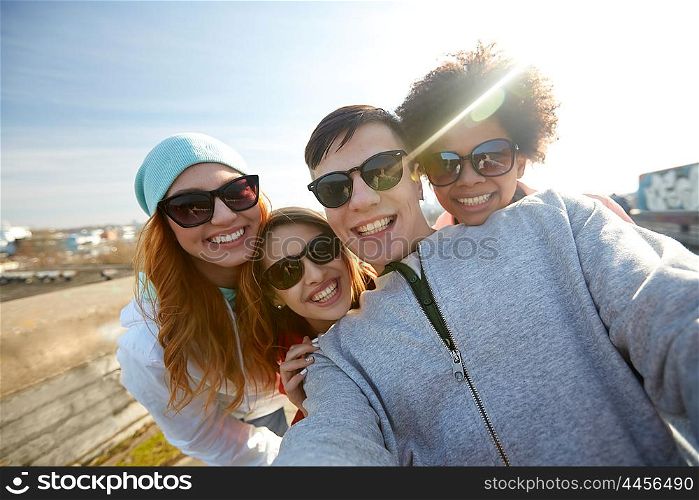 tourism, travel, people, leisure and technology concept - group of smiling teenage friends taking selfie on city street