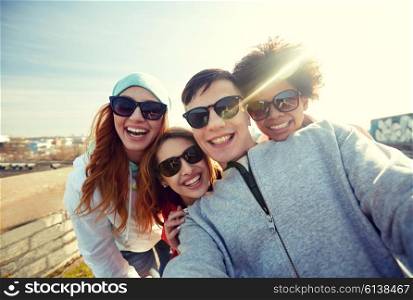 tourism, travel, people, leisure and technology concept - group of smiling teenage friends taking selfie on city street