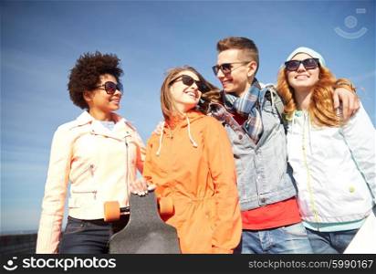 tourism, travel, people, leisure and teenage concept - group of happy friends in sunglasses hugging and talking on city street