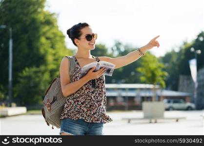 tourism, travel, summer holidays and people concept - happy teenage girl with guidebook and backpack in city