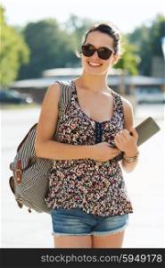 tourism, travel, summer holidays and people concept - happy teenage girl with tablet pc computer and backpack in city