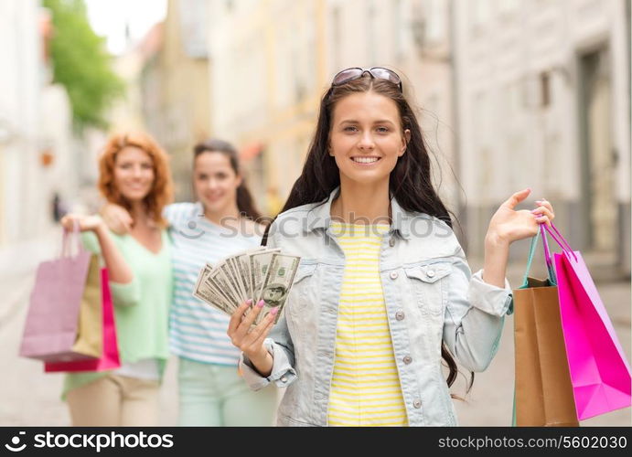 tourism, travel, vacation, shopping and friendship concept - smiling teenage girls with shopping bags on street