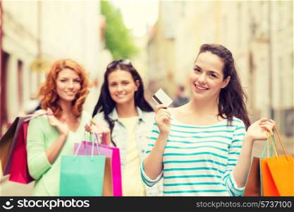 tourism, travel, vacation, shopping and friendship concept - smiling teenage girls with shopping bags on street