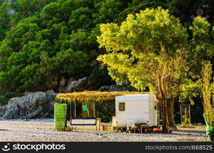 Tourism vacation and travel. Caravan trailer on sunny beach in Greece. Caravan trailer on sunny beach