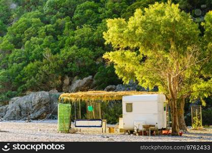 Tourism vacation and travel. Caravan trailer on sunny beach in Greece. Caravan trailer on sunny beach