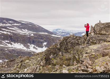 Tourism vacation and travel. Female tourist taking photo with camera, enjoying mountains landscape from Dalsnibba viewpoint, Norway Scandinavia.. Tourist taking photo from Dalsnibba viewpoint Norway