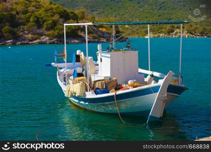 Tourism vacation and travel. Fishing boat on blue sea surface in greek resort marina.. Fishing boat in greek marina