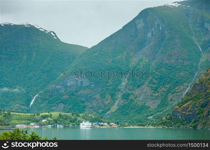 Tourism vacation and travel. Mountains landscape and big cruise ship on fjord Sognefjord in Flam Norway Scandinavia.. Cruise ship on fjord Sognefjord in Flam Norway