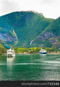Tourism vacation and travel. Mountains landscape and big cruise ship on fjord Sognefjord in Flam Norway Scandinavia.. Cruise ship on fjord Sognefjord in Flam Norway