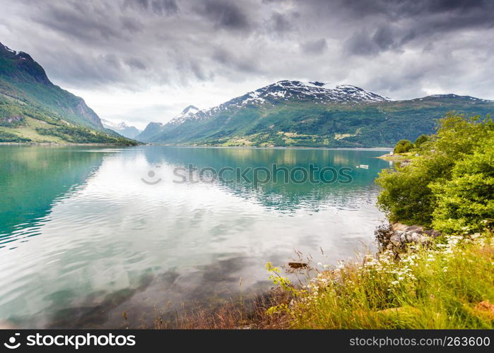 Tourism vacation and travel. Mountains landscape dark stormy clouds and fjord in Norway Scandinavia Europe. Beautiful nature. Mountains landscape and fjord in Norway