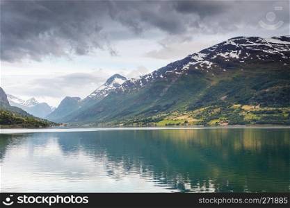 Tourism vacation and travel. Mountains landscape dark stormy clouds and fjord in Norway Scandinavia Europe. Beautiful nature. Mountains landscape and fjord in Norway