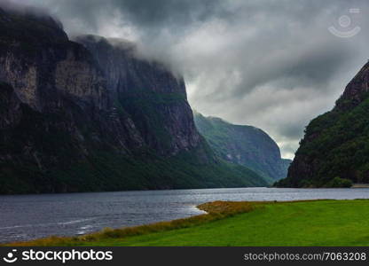 Tourism vacation and travel. Mountains landscape with stormy clouds and fjord in Norway Dalane region, Scandinavia.. Cloudy rainy mountains and fjord in Norway,
