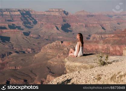 Tourist at Grand Canyon. Tourist at Grand Canyon sitting on the rock edge, Arizona, USA