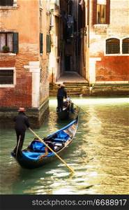 tourist attractions: Venice at the sunset. The focus is on the left wall while Gondolas are slightly blurred