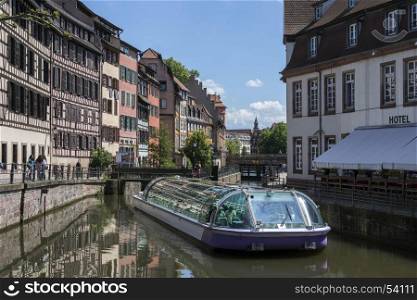 Tourist boat and old buildings in the historic Little Venice area of the city of Strasbourg in the Alsace region of France. This area of the city is a UNESCO World Heritage Site.
