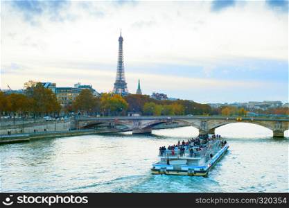 Tourist boat at Sienna river, Paris skyline with Eiffel tower in background, France