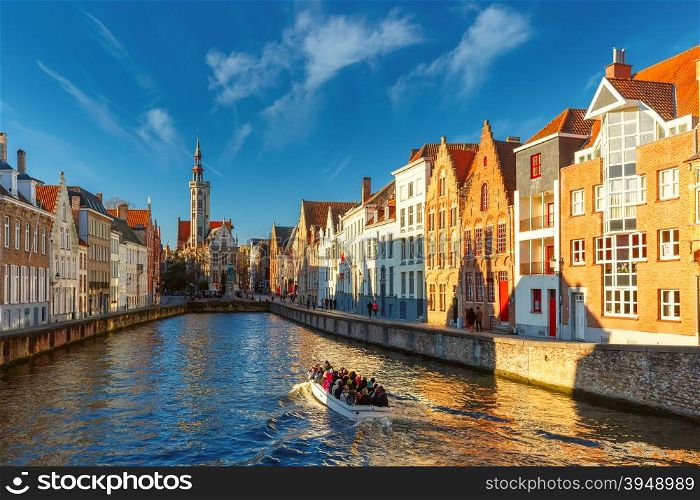 Tourist boat on canal Spiegelrei and Jan Van Eyck Square in the morning in Bruges, Belgium