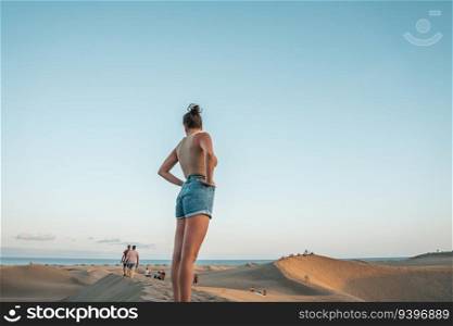 Tourist contemplating the people on Maspalomas desert in Gran Canaria, Canary Islands, Spain