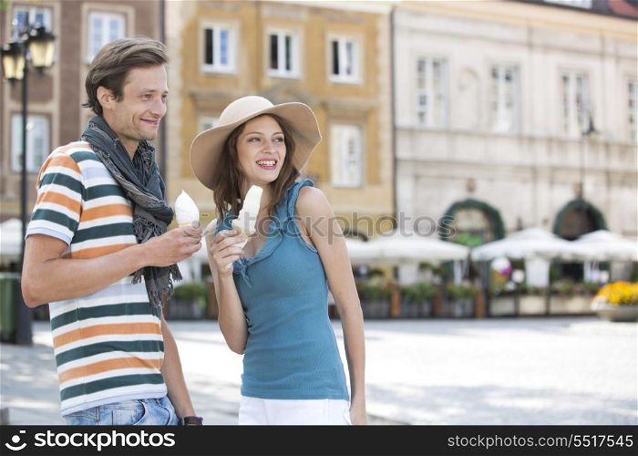 Tourist couple enjoying ice cream cones during vacation