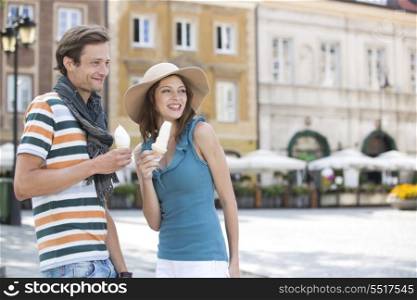 Tourist couple enjoying ice cream cones during vacation