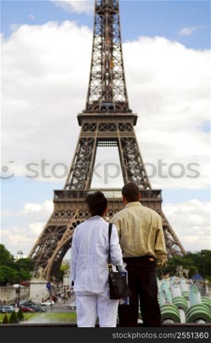 Tourist couple enjoying the view of Eiffel tower in Paris, France.