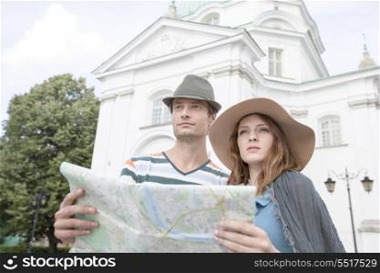 Tourist couple holding map outside St. Casimir Church; Warsaw; Poland