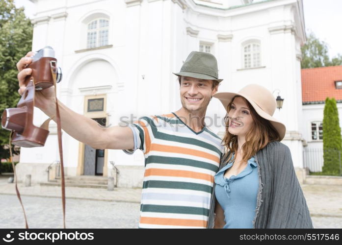 Tourist couple taking self portrait outside St. Casimir Church; Warsaw; Poland