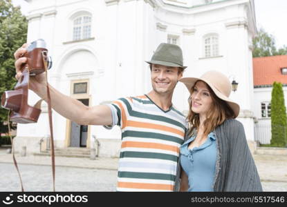 Tourist couple taking self portrait outside St. Casimir Church; Warsaw; Poland