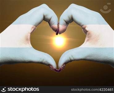 Tourist gesture made by argentina flag colored hands showing symbol of heart and love during sunrise