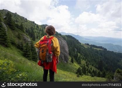 tourist girl standing on the trail in the mountains