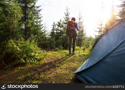 tourist girl stands near the tent in the mountain. Carpathians, Ukraine.