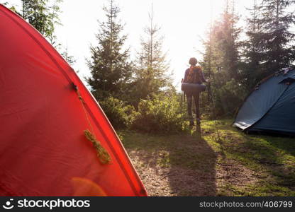 tourist girl stands near the tent in the mountain. Carpathians, Ukraine.