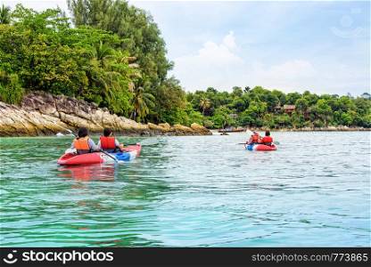 Tourist group are kayaking on the sea, travel by boat to see the beautiful nature landscape in the morning of summer at front the resort around Ko Lipe island, Tarutao National Park, Satun, Thailand. Tourist group are kayaking on the sea at Ko Lipe, Thailand
