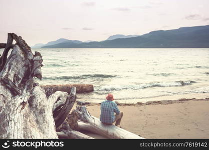 Tourist in Pacific ocean coast in British Columbia, Canada. Wanderlust travel concept.