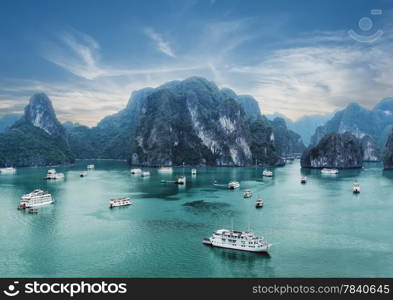 Tourist junks floating among limestone rocks at early morning in Ha Long Bay, South China Sea, Vietnam, Southeast Asia. Two images panorama