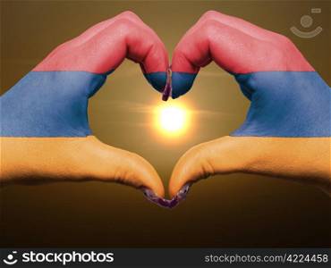 Tourist made gesture by armenia flag colored hands showing symbol of heart and love during sunrise