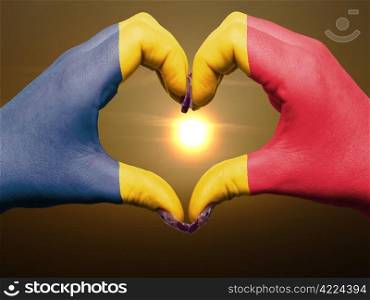 Tourist made gesture by chad flag colored hands showing symbol of heart and love during sunrise