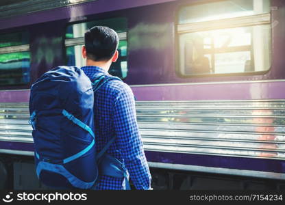 Tourist man backpacker using map to travel at train station